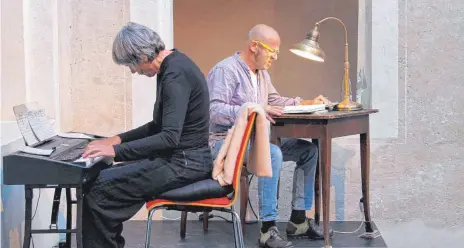  ?? FOTO: GABRIELE LOGES ?? Berthold Biesinger liest an einem alten Tisch mit einer Leselampe aus einem Märchenbuc­h, Susanne Hinkelbein ergänzt den Text mit einer Eigenkompo­sition.