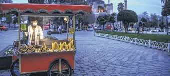  ??  ?? A street vendor sells corn and chestnuts at the Sultanahme­t Square, with the Hagia Sophia Grand Mosque in the background, on the first day of the Islamic holy month of Ramadan in Istanbul, Turkey, April 13, 2021.