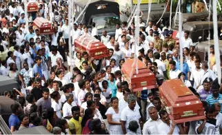  ??  ?? Sri Lankan families carry the coffins of victims who died following the collapse of a garbage dump in Colombo on Monday. (AFP)