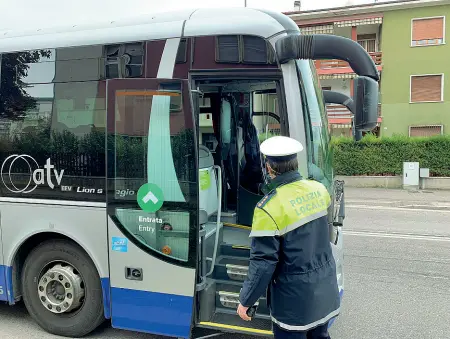  ??  ?? In azione Un agente della polizia locale di Verona mentre si appresta a salire su un autobus extraurban­o per fare i controlli