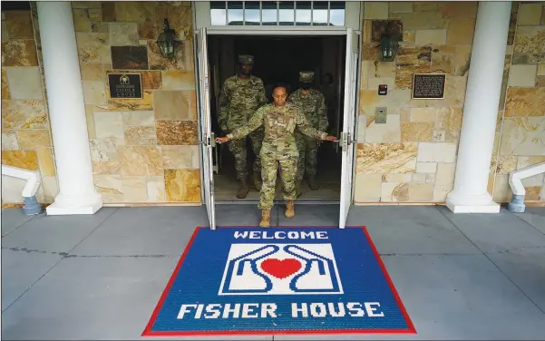  ??  ?? Tech Sgt. Ashley Harrell, joined by Senior Airman Myguerson Sainvilus (left) and Senior Airman lyana Green (right), opens the doors of Dover Fisher House on June 21 at Dover Air Force Base, Del. Dover Fisher House provides short-term, on-base lodging to families who travel to Dover Air Force base to witness the dignified transfer of their loved ones.