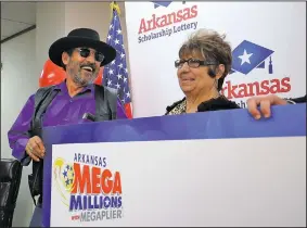  ?? Arkansas Democrat-Gazette/STEPHEN B. THORNTON ?? Eliberto Cantu and his wife, Anita, smile Monday while holding up their check from the Arkansas Scholarshi­p Lottery for winning the Mega Millions jackpot.