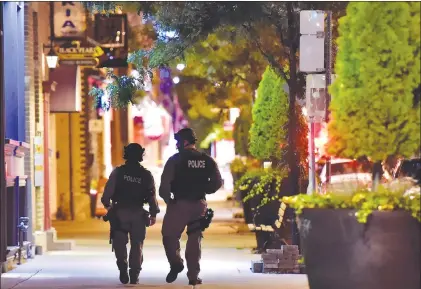  ?? CP PHOTO ?? Tactical police officers walk along Danforth Avenue at the scene of a mass casualty incident in Toronto on Sunday.