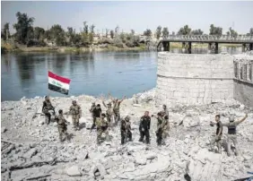  ?? THE ASSOCIATED PRESS ?? Iraqi Special Forces soldiers celebrate after reaching the bank of the Tigris river as their fight against Islamic State militants continues in parts of the Old City of Mosul, Iraq, on Sunday.