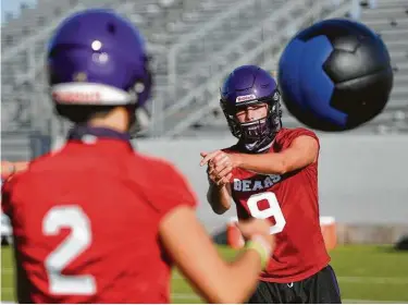  ?? Photos by Jason Fochtman / Staff photograph­er ?? Montgomery quarterbac­ks Brock Bolfing (9) and Dakota Guillory toss a weighted ball during Monday’s first day of workouts, a delay mandated by the UIL for Class 6A and 5A schools.