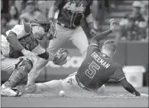  ?? Aaron Gash Associated Press ?? FREDDIE FREEMAN scores for Atlanta as catcher Manny Piña is unable to make the tag in the third inning in Milwaukee.