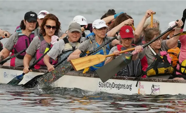  ?? Sebastian Foltz/Post-Gazette ?? Members of the Steel City Dragons Pink Steel and Pittsburgh Unity dragon boat teams practice alongside first-time paddlers during a session Tuesday on the Allegheny River by the Fox Chapel Yacht Club.