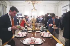  ?? Saul Loeb / AFP/Getty Images ?? Guests select fast food that President Donald Trump purchased for a ceremony honoring the national football champion Clemson Tigers in the State Dining Room of the White House on Monday. Trump says the White House chefs are furloughed due to the partial government shutdown.