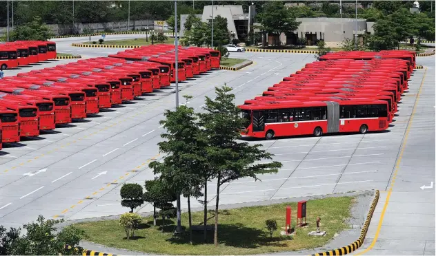  ?? Agence France-presse ?? Metro buses can be seen parked at a depot as they stopped from plying during a nine-day nationwide lockdown in Islamabad on Wednesday.