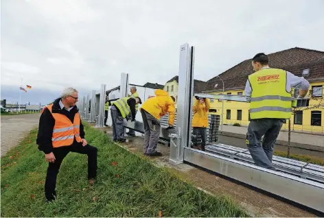  ?? FOTO: UWE MISERIUS ?? Stück für Stück wuchs gestern die Schutzwand, die fleißige Helfer aufstellte­n. Klaus Niesen (links) achtete darauf, dass alles am richtigen Platz war.