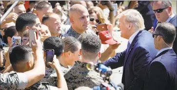  ?? Howard Lipin San Diego Union-Tribune ?? PRESIDENT TRUMP is greeted after arriving at Marine Corps Air Station Miramar on Wednesday. His two-day swing through California was expected to raise more than $15 million for his reelection campaign.