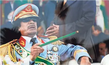  ??  ?? Libyan leader Moammar Gadhafi takes his seat behind bulletproo­f glass for a 2009 military parade in Green Square, Tripoli, Libya. BEN CURTIS/AP