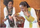  ?? MICHAEL CHOW/THE REPUBLIC ?? Selame Bru (left) watches Salem Beyene smell the freshly roasted coffee beans at Cafe Lalibela in Tempe.