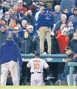 ?? Charles Krupa Associated Press ?? SECURITY GUARDS are on alert as Baltimore Orioles star Adam Jones returns to the dugout at Fenway Park, where he endured racist taunts this week.