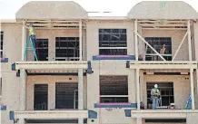  ?? GAVIN YOUNG ?? Constructi­on workers work on a townhouse project in Sage Hill on the northern edge of Calgary.