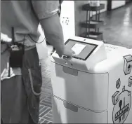  ?? PROVIDED TO CHINA DAILY ?? A merchant puts take-away food into an autonomous delivery robot developed by Segway Robotics.