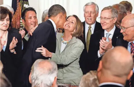  ?? CHIP SOMODEVILL­A/GETTY IMAGES ?? President Barack Obama embraces Speaker of the House Nancy Pelosi after signing the Affordable Care Act in the East Room of the White House on March 23, 2010.