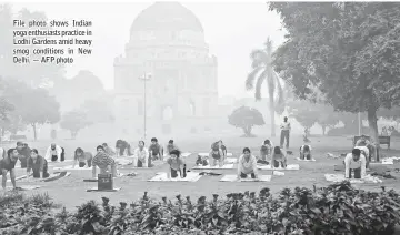  ??  ?? File photo shows Indian yoga enthusiast­s practice in Lodhi Gardens amid heavy smog conditions in New Delhi. — AFP photo