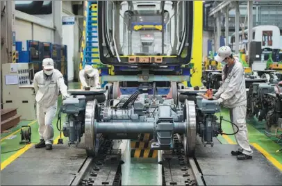  ?? CHEN SIHAN / XINHUA ?? CRRC Zhuzhou Locomotive technician­s work at the company’s factory in Changsha, Hunan province.