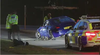  ??  ?? Police at the crash examining one of the cars that ploughed into spectators on the side of the road