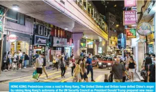  ?? — AFP ?? HONG KONG: Pedestrian­s cross a road in Hong Kong. The United States and Britain have defied China’s anger by raising Hong Kong’s autonomy at the UN Security Council as President Donald Trump prepared new measures against Beijing.