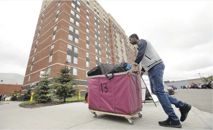  ?? PHOTOS/DAVID BLOOM ?? Dhaneshwar­an Moonian, 20, from the Indian Ocean island of Mauritius moves into the MacEwan University student residence in Edmonton on Sunday. Approximat­ely 725 students moved into the residence that day.