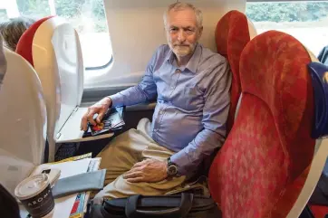  ??  ?? Are you sitting comfortabl­y? Jeremy Corbyn bagged two seats during his train journey yesterday