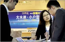  ?? PROVIDED TO CHINA DAILY ?? A China Evergrande salesperso­n introduces the property developer’s apartment project to customers at a real estate expo in Guangzhou, Guangdong province.