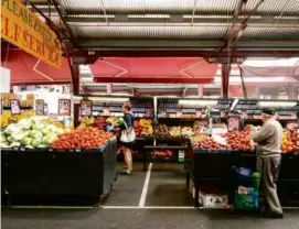  ?? SUSAN WRIGHT/THE NEW YORK TIMES ?? Produce stalls at Queen Victoria Markets in Melbourne. The price of bread has risen 24 percent in Australia since 2021.