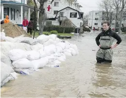  ?? PIERRE OBENDRAUF ?? Valérie Turcotte looks at sandbags surroundin­g her St-Martin St. triplex in Pierrefond­s. Borough Mayor Jim Beis is calling for volunteers to help dispose of the sandbags used during the flooding.