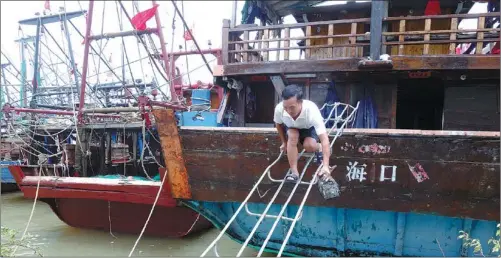  ?? HUANG YIMING / CHINA DAILY ?? A fisherman leaves his boat after it was called back from a trip due to a typhoon alert issued by meteorolog­ical authoritie­s on Friday. More than 20,000 fishing boats in Hainan province were instructed to return to harbor.