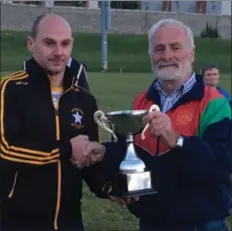  ??  ?? Injured captain Aidan Murphy receives the cup from Tom Boland.