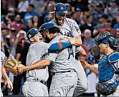  ?? NORM HALL/GETTY ?? Yasmani Grandal, left, and Kenley Jansen hug after the Dodgers’ sweep as Clayton Kershaw leaps into the party.