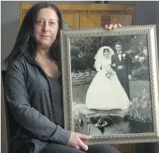  ?? BRUCE DEACHMAN ?? Sonia Perna holds a photo from her parents’ wedding. Her parents met at St. Anthony’s church. Perna’s mom died at age 60.