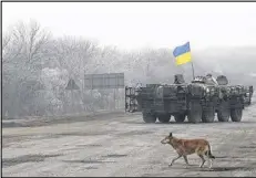  ?? AP ?? A Ukrainian armored vehicle travels between Dabeltseve and Artemivsk, Ukraine, on Saturday. Under an agreement, Ukrainian forces and Russian-backed separatist­s are to begin pulling back their heavy weaponry.