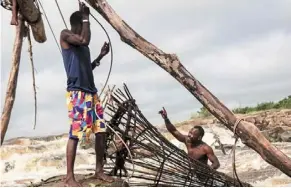  ?? — photos: afp ?? aluka (right), searching for fish with a traditiona­l creel at the Wagenya Falls in Kisangani.