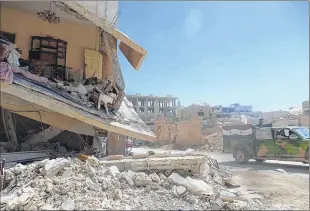  ?? ASSOCIATED PRESS ?? Syrian soldiers in a truck pass through a heavily damaged area Monday after their victory against the Islamic State group in Qaryatain, Syria.