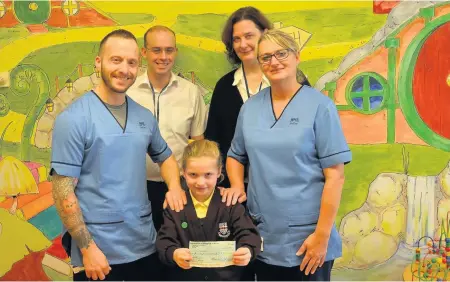  ??  ?? Joyful occasion Grateful Joy Little, 7, presents the cheque to the Wishaw team