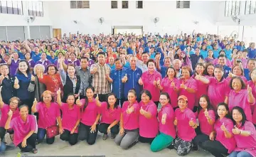  ??  ?? Dr Penguang (standing, sixth right), his wife Monica Ukong (on his left) and participan­ts of the women empowermen­t programme show their thumbs-up after the event.