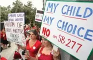  ?? RICH PEDRONCELL­I/THE ASSOCIATED PRESS FILE PHOTO ?? Protesters rally against a California measure requiring schoolchil­dren to get vaccinated.
