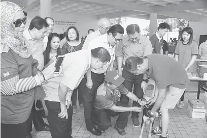  ??  ?? PERCUMA: Sebastian, Lee dan Adam (dua dari kiri) menyaksika­n kelancaran program vaksinasi rabies di Dewan Suarah Miri semalam.