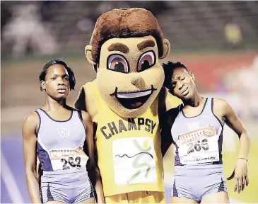  ??  ?? Marleena Eubanks of Edwin Allen (left), the Class Two girls 1,500m winner and her teammate, Sanikee Gardner, being congratula­ted by Champsy at the ISSA-GraceKenne­dy Boys and Girls’ Athletics Championsh­ips in 2012.