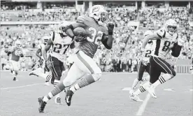  ?? MICHAEL REAVES GETTY IMAGES ?? Kenyan Drake (32) of the Miami Dolphins carries the ball for the game-winning touchdown in the fourth quarter against the New England Patriots on Sunday.