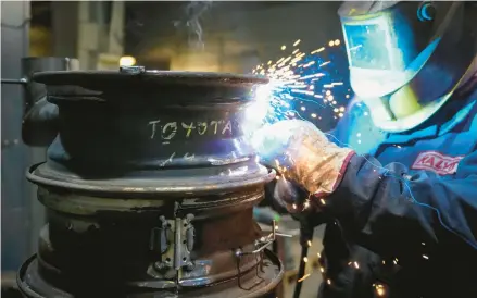  ?? SERGEI GRITS/AP ?? A volunteer metalworke­r fashions a heating stove from old car rims Feb. 2 in a workshop in Siauliai, Lithuania, northwest of the capital Vilnius.