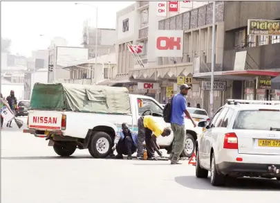  ?? Picture by Shelton Muchena ?? A man fixes a car in the middle of Robson Manyika Avenue next to the Central Vehicle Registry, disrupting the smooth flow of traffic yesterday.