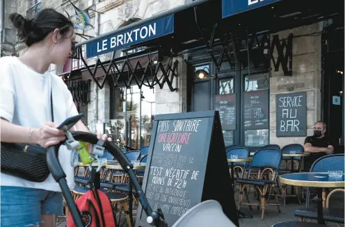  ?? PHILIPPE LOPEZ AGENCE FRANCE-PRESSE ?? Le passeport sanitaire est désormais réclamé à l’entrée des bars, restaurant­s, hôpitaux et transports interrégio­naux partout en France.