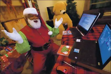  ?? LM OTERO — THE ASSOCIATED PRESS ?? Larry Jefferson portrays Santa Claus and conducts a visit via a computer screen with Raquel Anaya and her cousins Lexi and Luna Reyes from his home in Duncanvill­e, Texas, on Dec. 9. The children lost a grandmothe­r to COVID-19 recently. In this socially distant holiday season, Santa Claus is still coming to towns (and shopping malls) across America but with a few 2020 rules in effect.