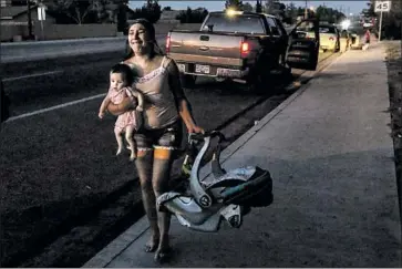  ?? Photograph­s by Irfan Khan Los Angeles Times ?? DAWN INSCORE, holding her infant, runs from her apartment in Ridgecrest, Calif., after a magnitude 7.1 quake struck the region Friday night. More than 2,000 Ridgecrest-area residents were left without power.