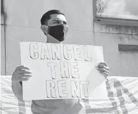  ?? ULYSSES MUÑOZ/BALTIMORE SUN ?? Gamal Karin Martinez holds a sign reading “Cancel The Rent” during a rally in front of the District Court of Maryland earlier in the summer.