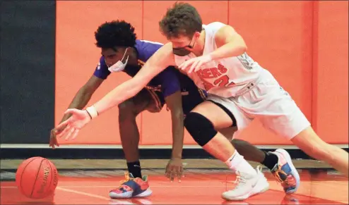  ?? Christian Abraham / Hearst Connecticu­t Media ?? Ridgefield’s Matthew Eiben (22) and Westhill’s JeySon Slade (2) reach for a loose ball during the FCIAC boys basketball championsh­ip game in Ridgefield on Friday. Ridgefield won 64-37 for its third straight FCIAC title.